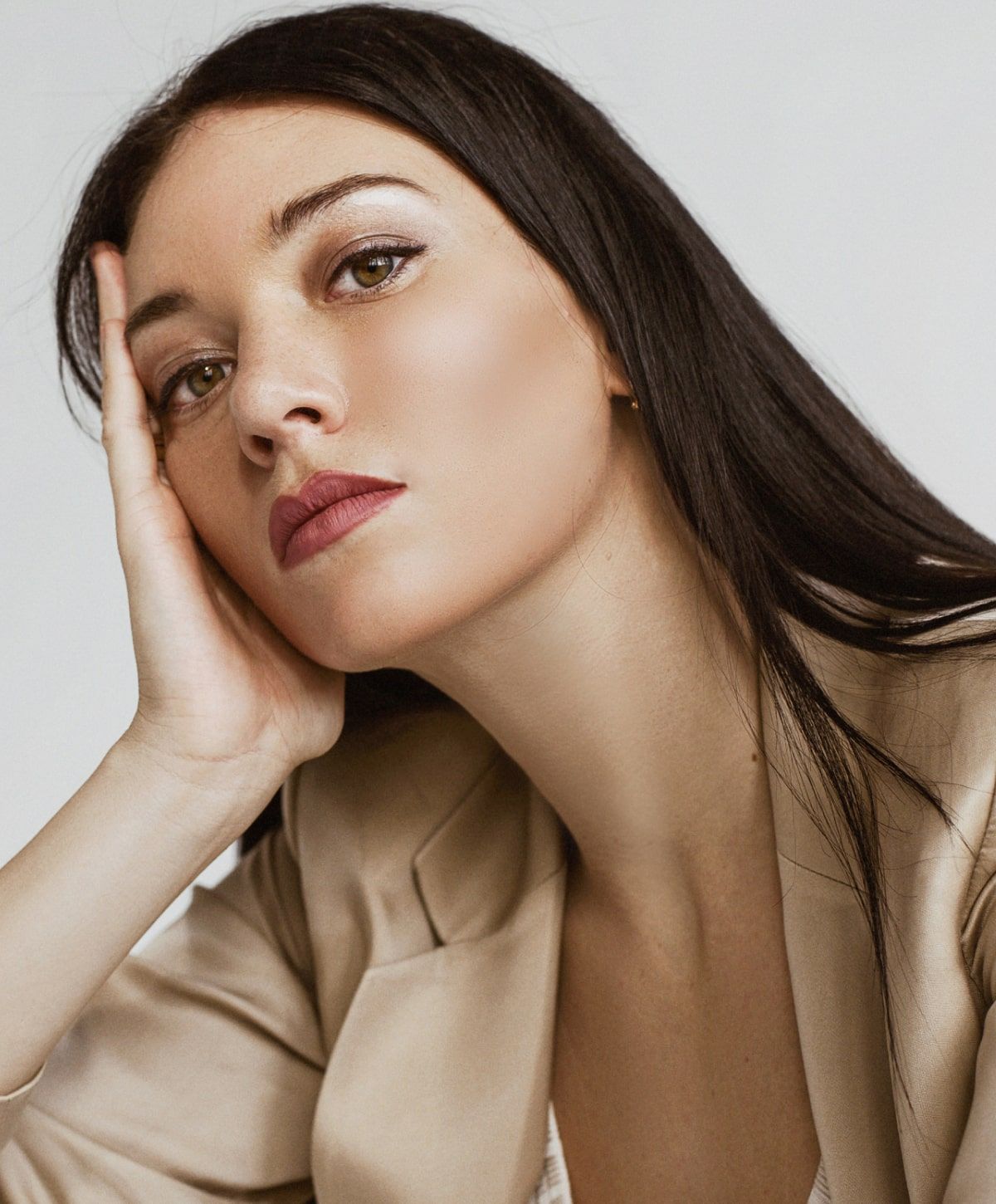 Woman resting her face in a contemplative pose.