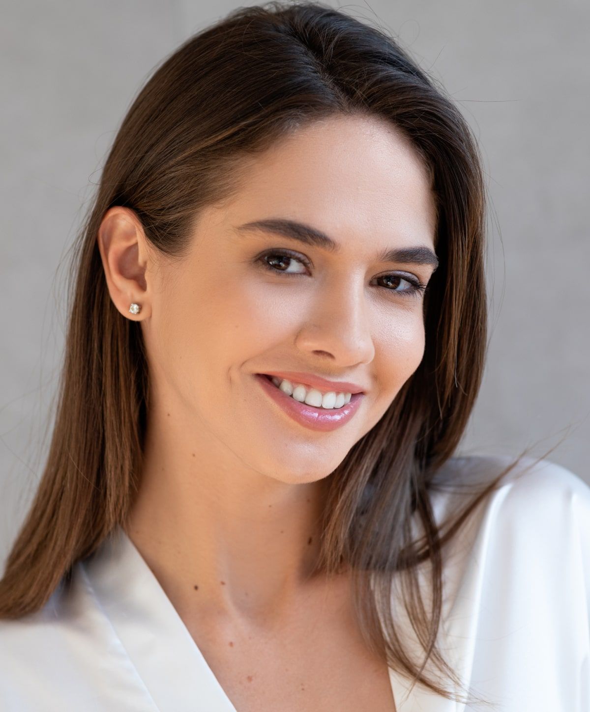 Smiling woman in a light-colored robe.