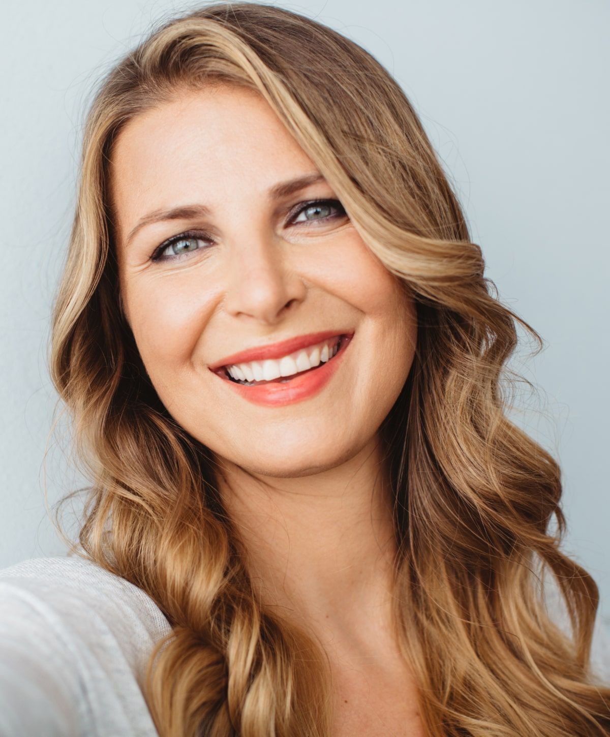 Smiling woman with long, wavy hair.